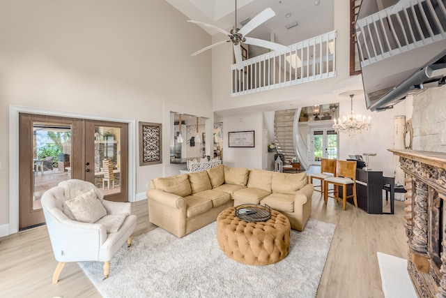 living room with a fireplace, a high ceiling, french doors, and wood-type flooring