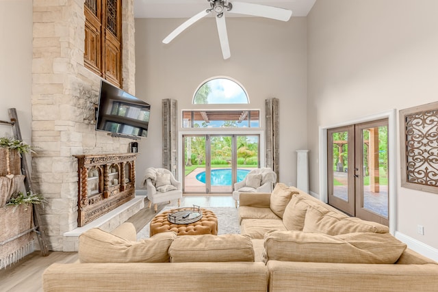 living room featuring high vaulted ceiling, light hardwood / wood-style flooring, a wealth of natural light, and ceiling fan