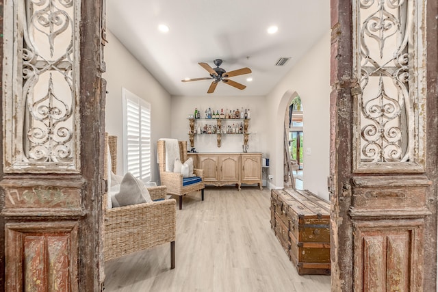 living area with ceiling fan and light hardwood / wood-style flooring