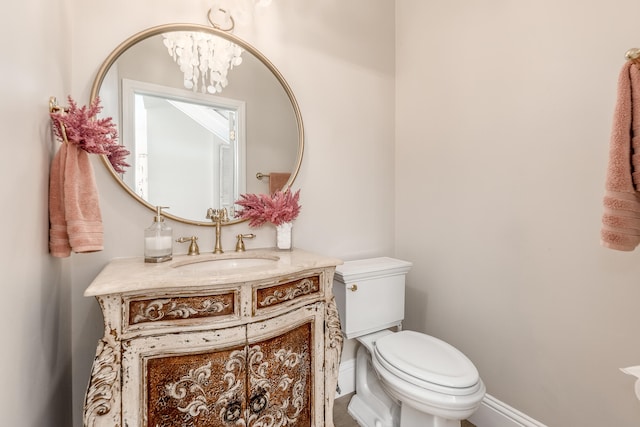 bathroom featuring vanity, a chandelier, and toilet