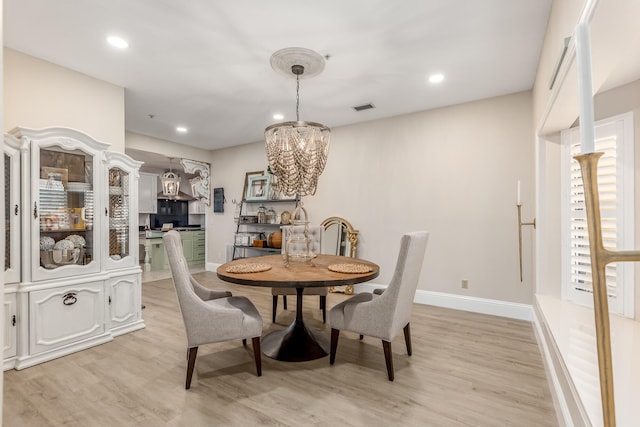 dining area featuring a notable chandelier and light hardwood / wood-style flooring