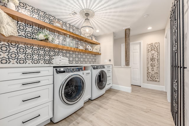 washroom featuring washer and clothes dryer, a chandelier, and light hardwood / wood-style flooring