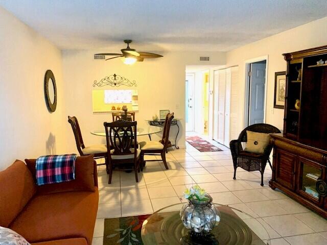 tiled living room with ceiling fan