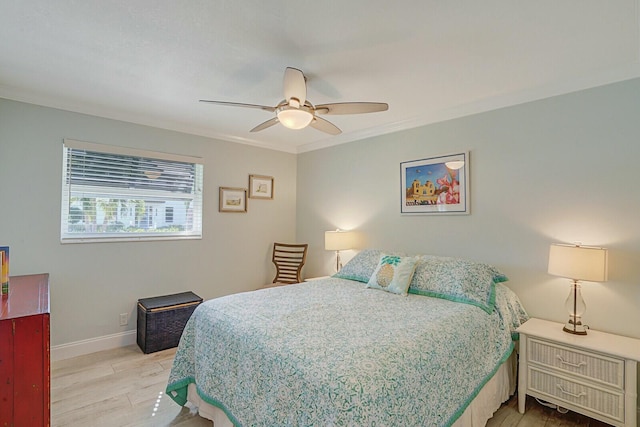 bedroom featuring ceiling fan, ornamental molding, light wood-type flooring, and baseboards