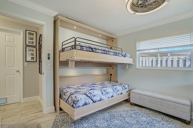 bedroom featuring baseboards, ornamental molding, and wood finished floors