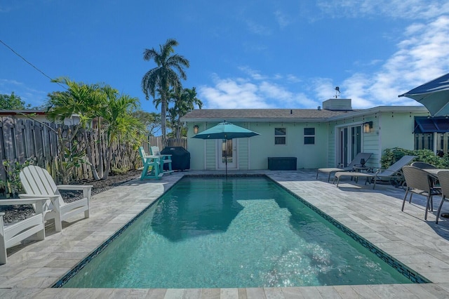 view of swimming pool featuring a grill and a patio