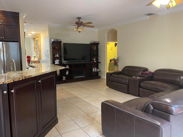 tiled living room featuring ceiling fan and crown molding