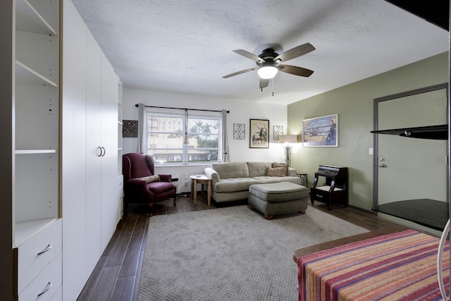 living room featuring a textured ceiling, ceiling fan, and dark hardwood / wood-style floors