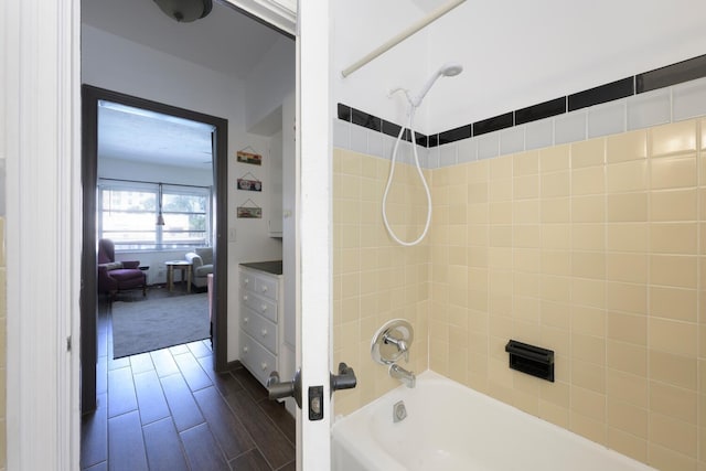 bathroom with tiled shower / bath combo and hardwood / wood-style flooring