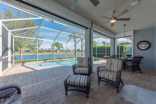 view of patio / terrace with a water view, ceiling fan, and a lanai