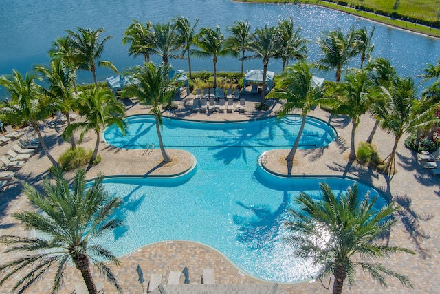 view of pool featuring a patio area and a water view