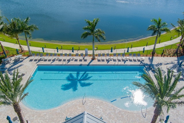 view of swimming pool featuring a patio and a water view