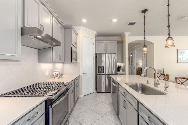 kitchen featuring sink, ornamental molding, appliances with stainless steel finishes, tasteful backsplash, and decorative light fixtures