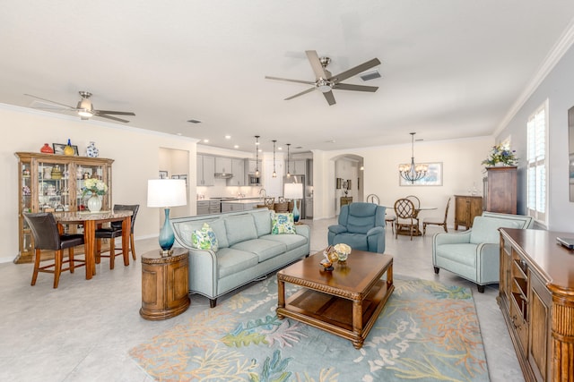 tiled living room featuring crown molding, sink, and ceiling fan with notable chandelier