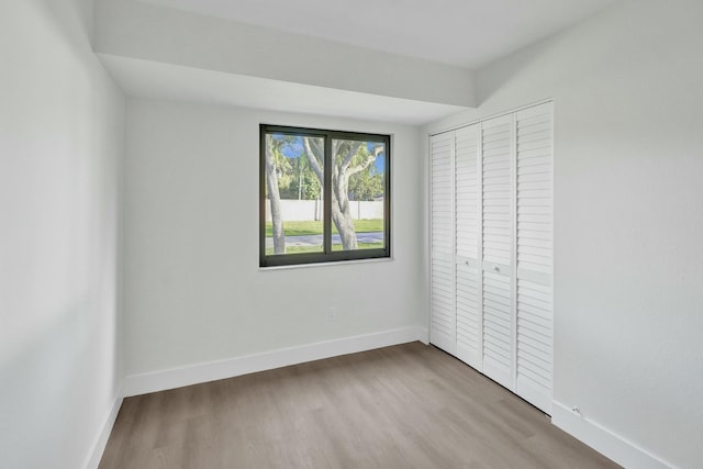 unfurnished bedroom featuring light wood-type flooring and a closet