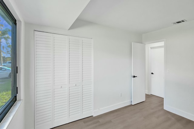 unfurnished bedroom featuring a closet and light hardwood / wood-style floors