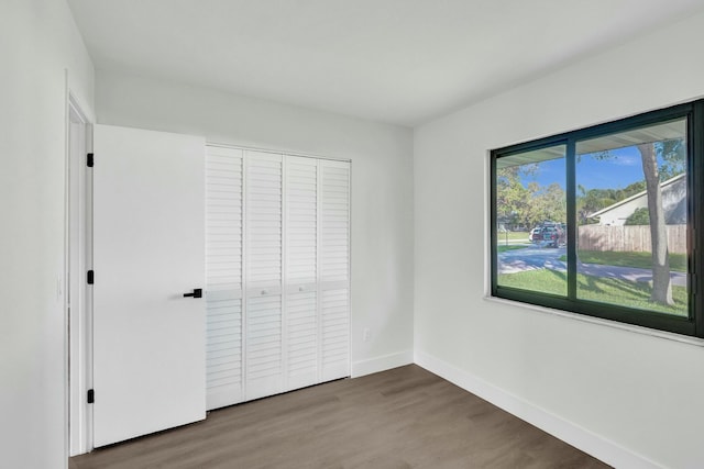 unfurnished bedroom featuring dark hardwood / wood-style floors and a closet