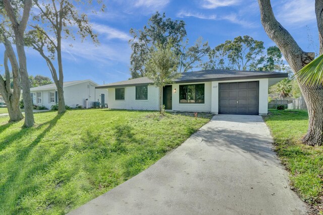 single story home with a garage and a front lawn