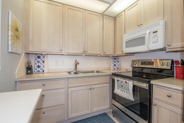 kitchen with stainless steel range with electric stovetop, sink, and light brown cabinetry