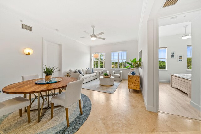 living room featuring light tile patterned floors, ceiling fan, crown molding, and sink