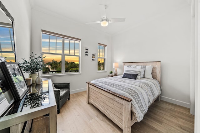 bedroom with ceiling fan, ornamental molding, and light hardwood / wood-style flooring