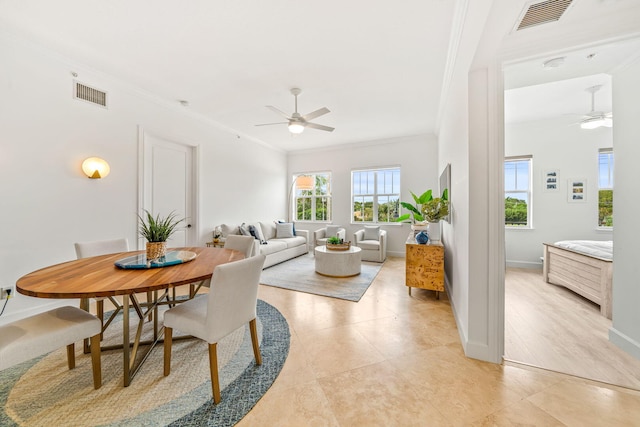 tiled dining space with crown molding and ceiling fan