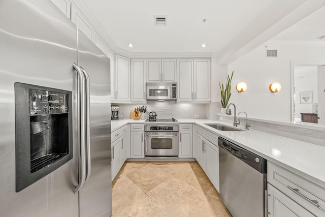 kitchen featuring decorative backsplash, light stone counters, ornamental molding, stainless steel appliances, and sink