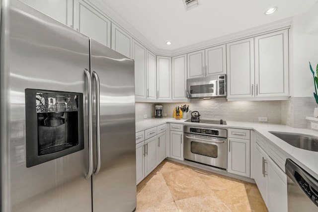 kitchen featuring decorative backsplash, white cabinets, and stainless steel appliances