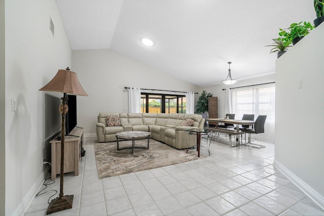 tiled living room featuring lofted ceiling and a textured ceiling