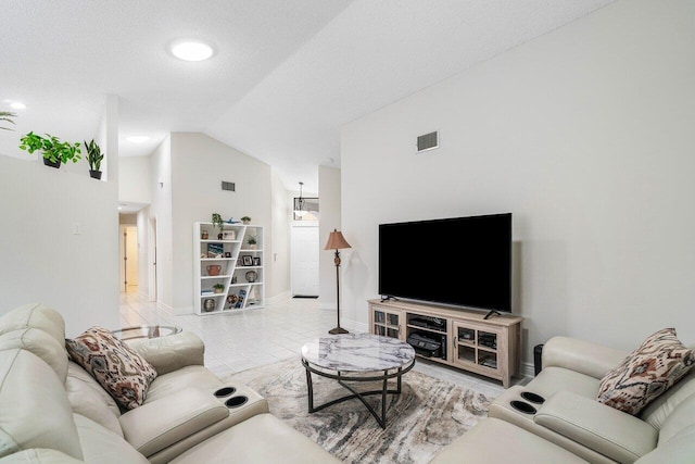 tiled living room featuring lofted ceiling and a textured ceiling