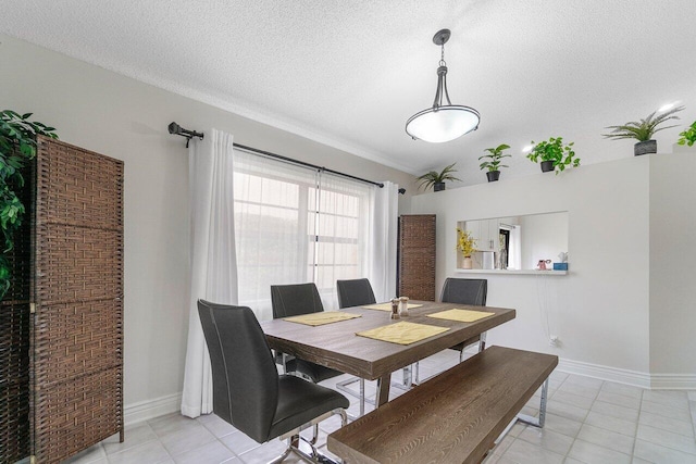 dining space featuring light tile patterned flooring and a textured ceiling