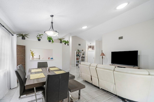 tiled dining space with lofted ceiling and a textured ceiling