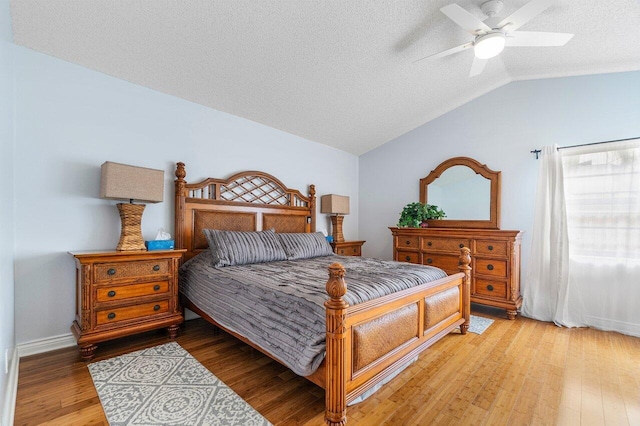 bedroom featuring wood-type flooring, lofted ceiling, ceiling fan, and a textured ceiling