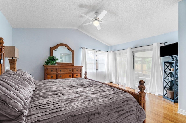 bedroom featuring lofted ceiling, a textured ceiling, light hardwood / wood-style floors, and ceiling fan