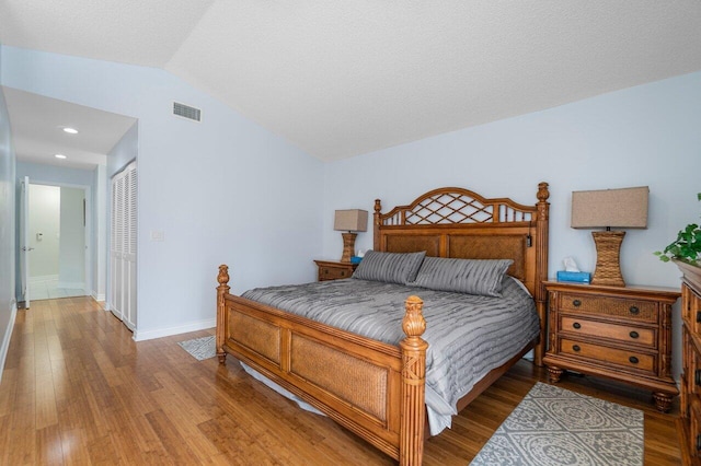 bedroom featuring vaulted ceiling, wood-type flooring, and a closet