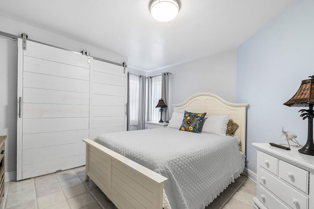 bedroom with a barn door and light tile patterned flooring