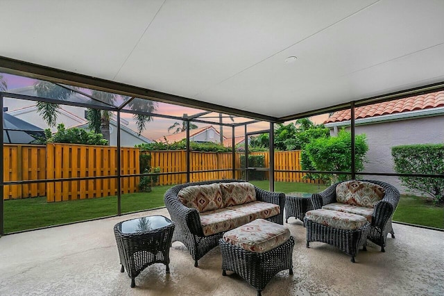 patio terrace at dusk featuring an outdoor hangout area and glass enclosure