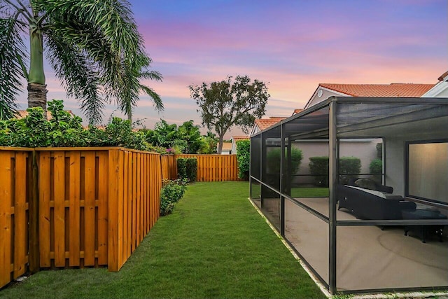 yard at dusk featuring a lanai