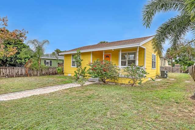 view of front of home featuring covered porch, central AC, and a front lawn