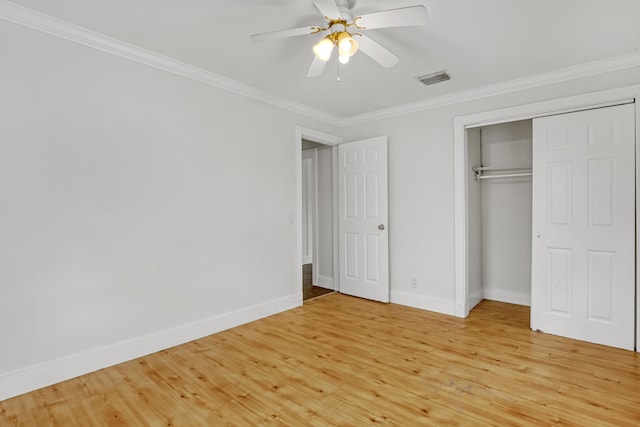 unfurnished bedroom featuring a closet, light hardwood / wood-style flooring, ceiling fan, and crown molding