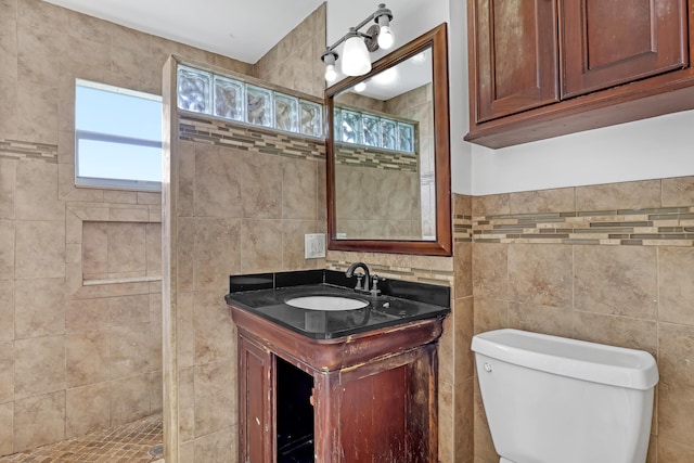 bathroom featuring vanity, toilet, and tile walls