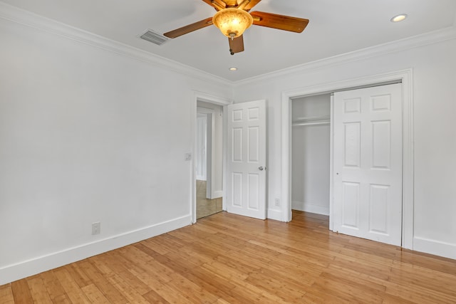 unfurnished bedroom featuring ceiling fan, a closet, ornamental molding, and light wood-type flooring