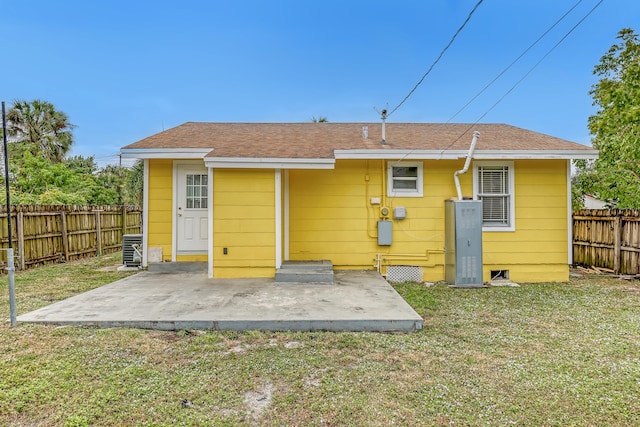 rear view of property featuring a lawn and a patio area