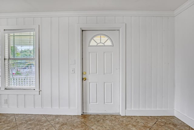 entrance foyer with tile patterned flooring, a healthy amount of sunlight, and ornamental molding