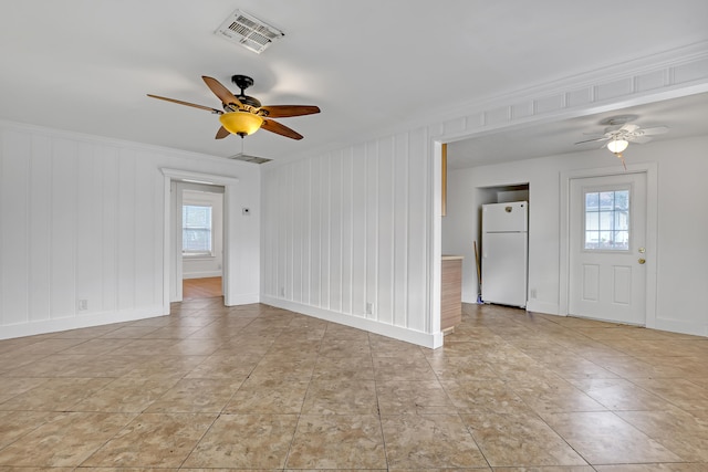 tiled empty room featuring ceiling fan and a wealth of natural light