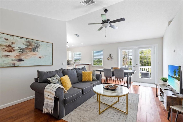 living room with ceiling fan, french doors, wood-type flooring, and lofted ceiling