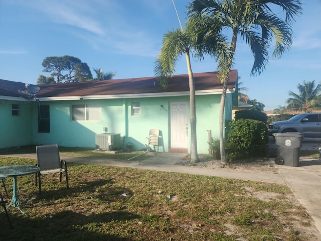 back of property featuring a yard and central AC