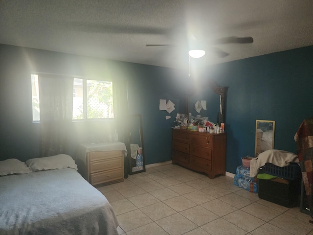 tiled bedroom featuring a textured ceiling and ceiling fan