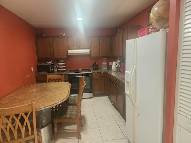 kitchen with stainless steel range oven, light tile patterned floors, and white refrigerator with ice dispenser