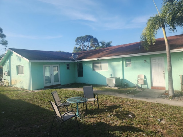 back of house with a lawn, french doors, a patio, and central AC unit